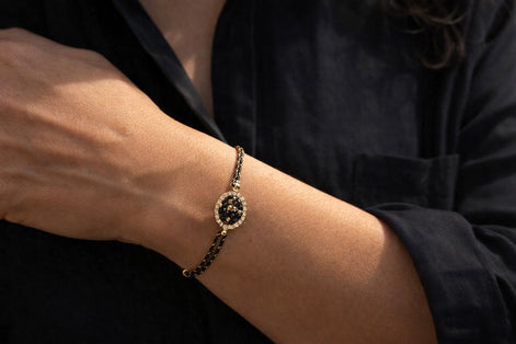 Bracelet cordon avec perles en verre et élément ovale – noir et doré